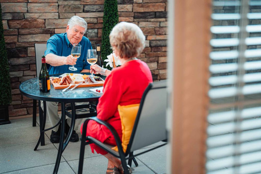 A senior couple dine in a private outdoor patio