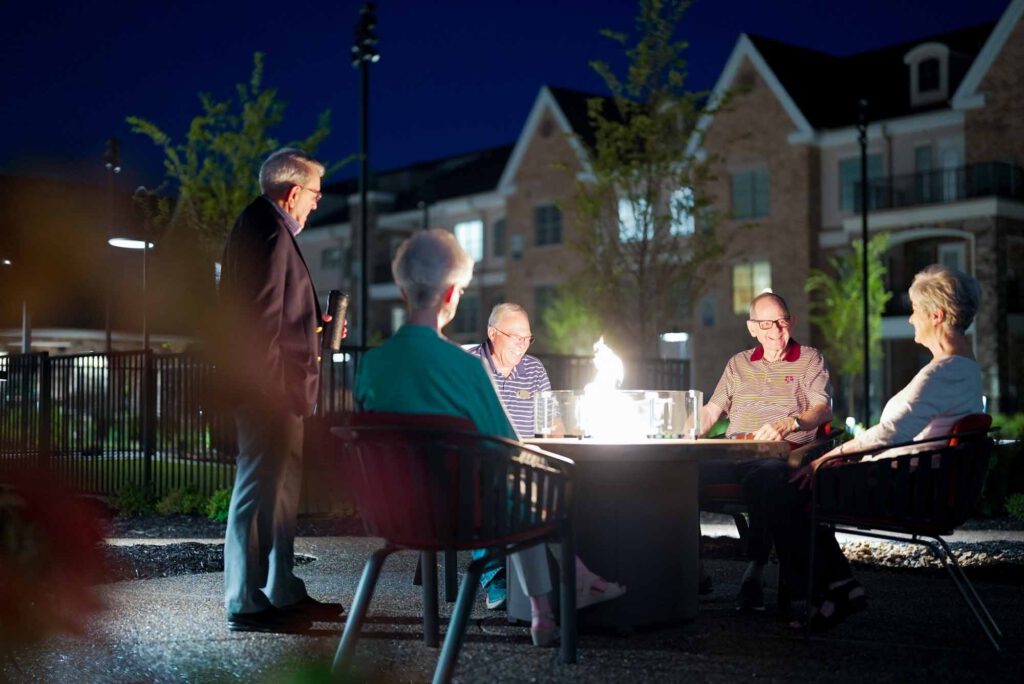 Senior adults around a fire pit at night
