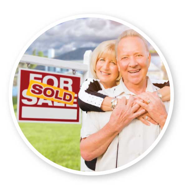 couple in front of a sold sign
