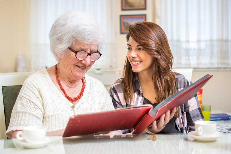 older and younger woman looking at album together