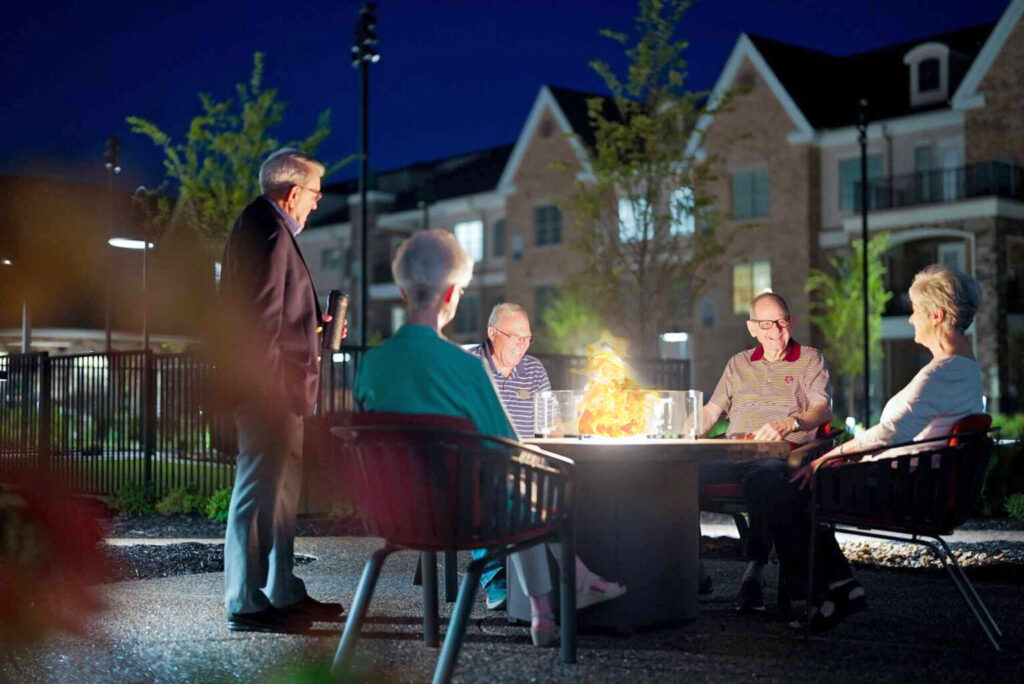 Senior adults around a fire pit at night